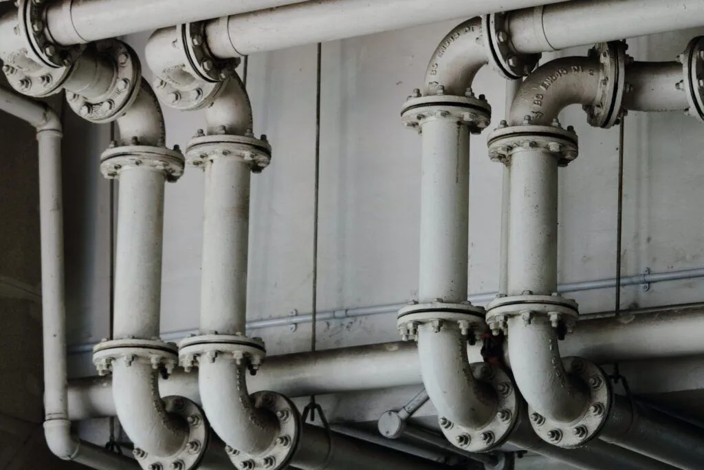 Monochrome image: Pipes are attached to a wall
