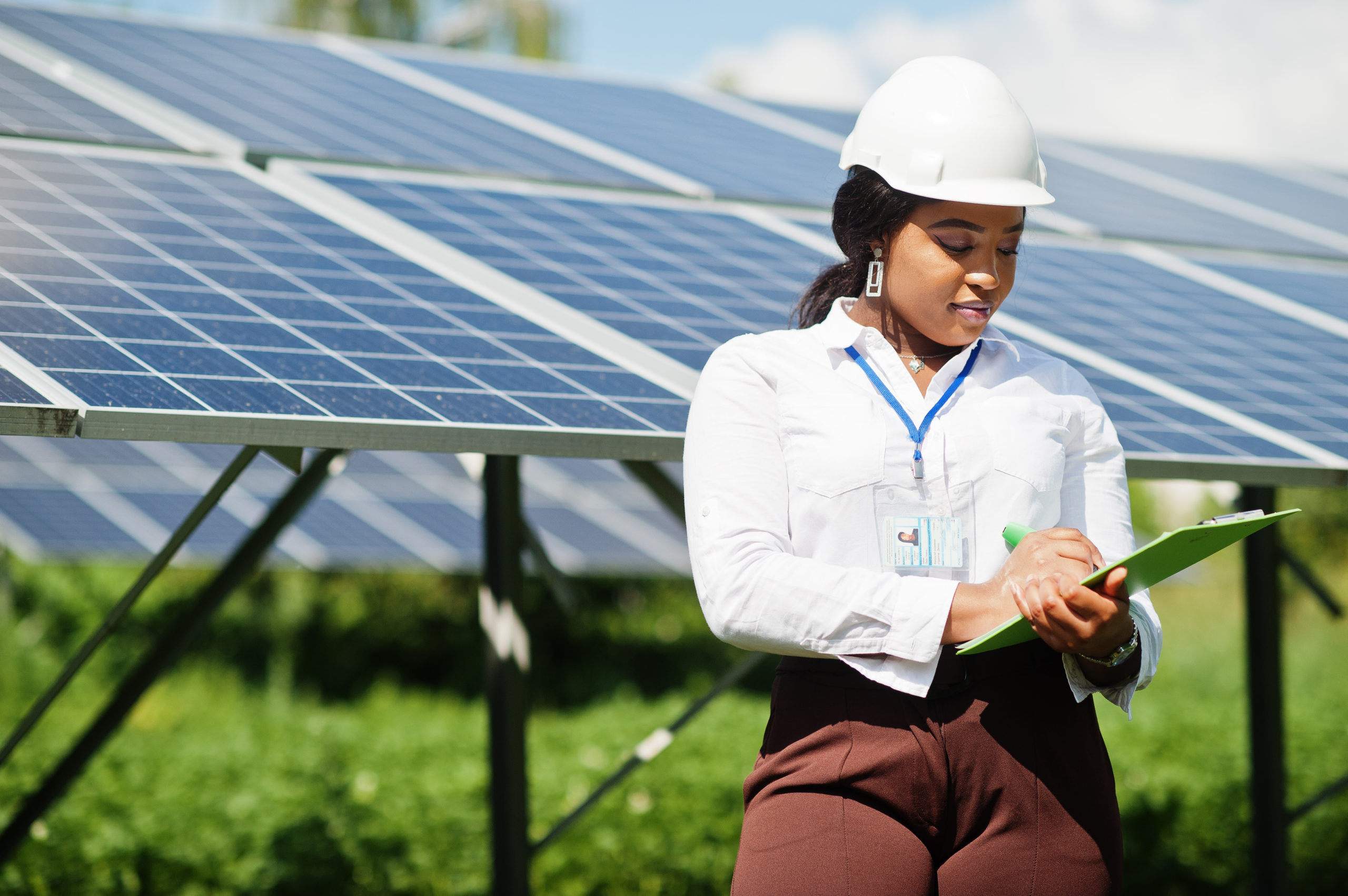 Smart Grid: A woman stands in front of solar panels with a clip board