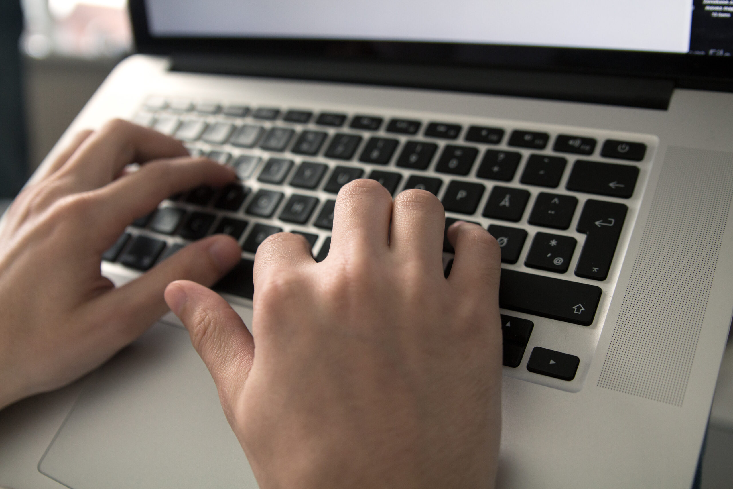 Digital Accessibility: A closeup of someone typing on a laptop keyboard.