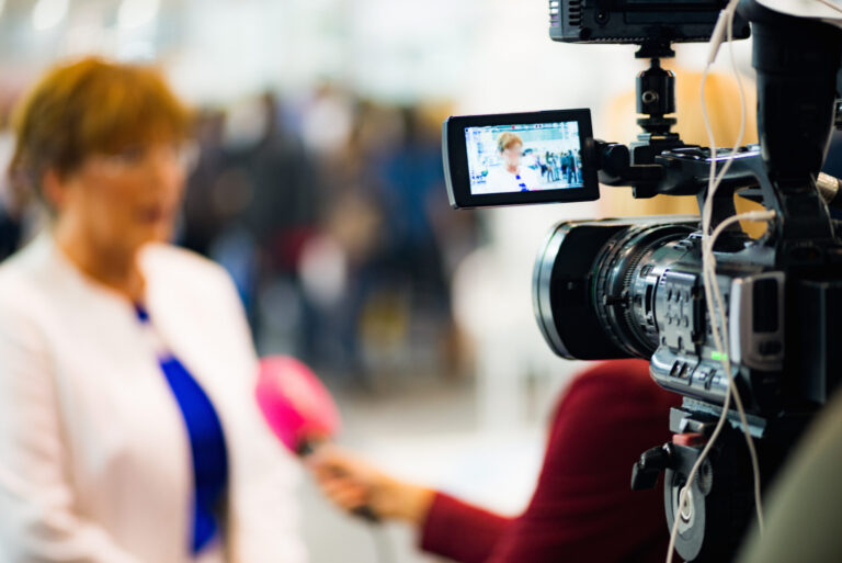 Local News: Cameraman recording interview at media press conference
